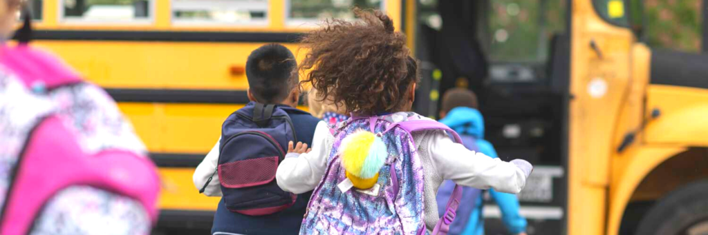 Children running toward a school bus