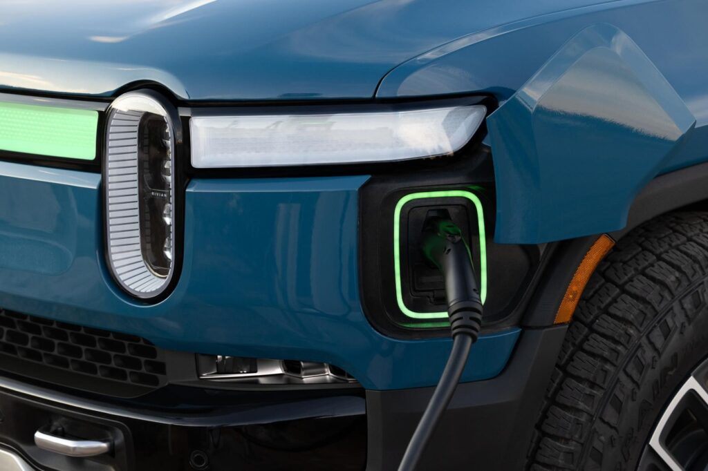 Rivian R1S SUV connected to charging station